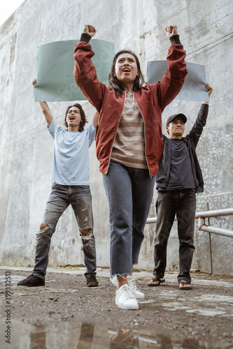 Portrait students holding blank paper who are burning with enthusiasm doing a demonstration together photo