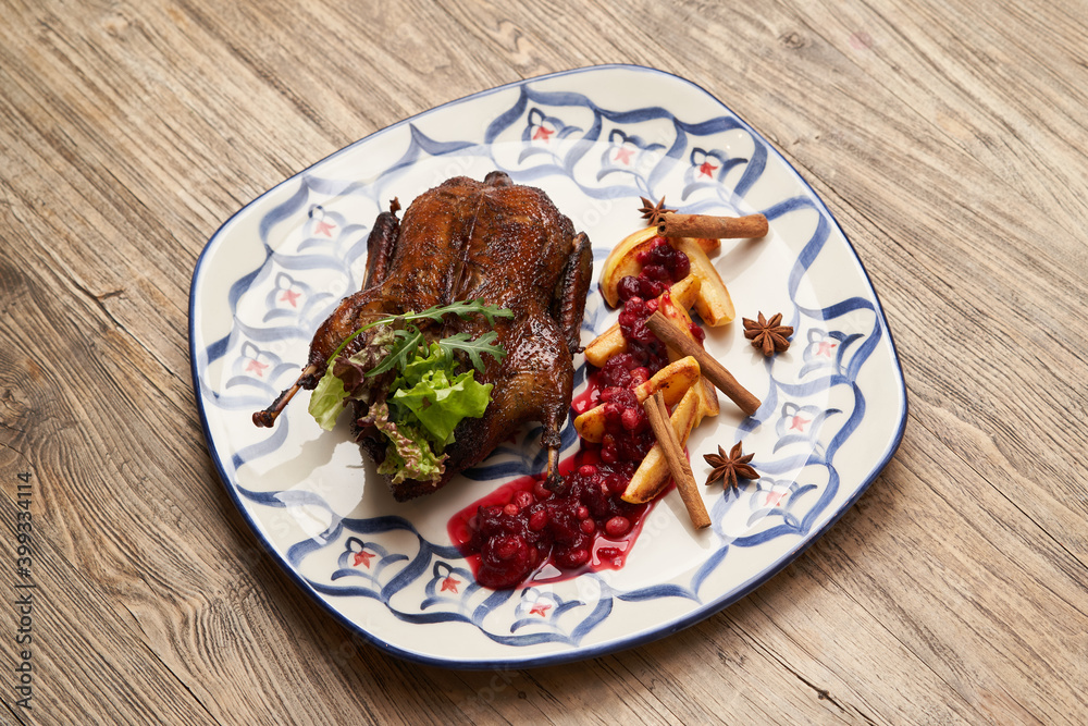 Roasted duck with quince on wooden table background