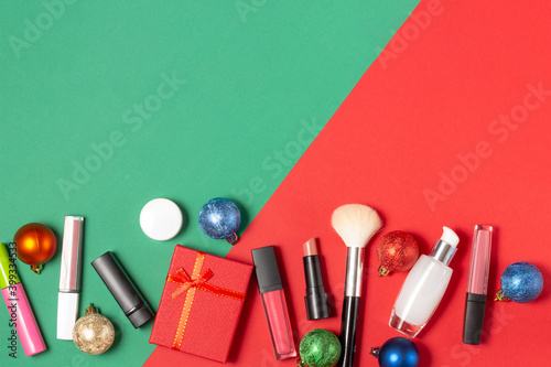 A set of facial cosmetics and a gift box on a red and green background.