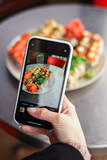 Girl makes a photo of sushi on the phone