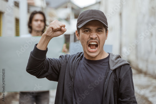 Portrait male students holding blank paper who are burning with enthusiasm doing a demonstration together photo