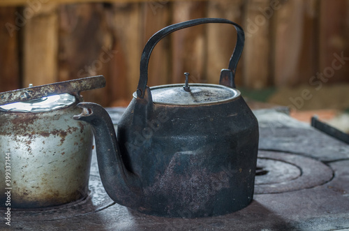 Beautiful steel kettle on wood stove in the countryside