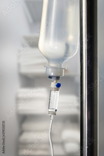 Closeup of a saline IV drip Infusion bottle with IV solution for patients in hospital, selective focus with blurred background