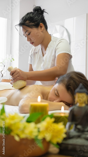 Young adult woman gets back massage at spa
