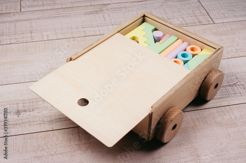 Children's toys made of natural material. Wooden construction kit in a large box-cars made of plywood.