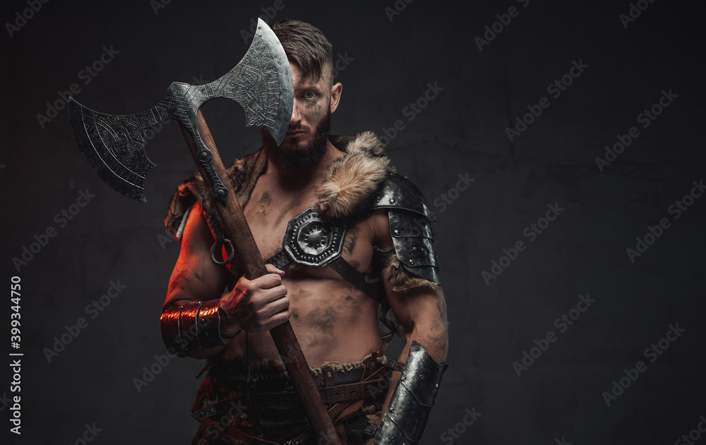 Armed with huge two handed axe nordic barbarian in light armour in dark background.