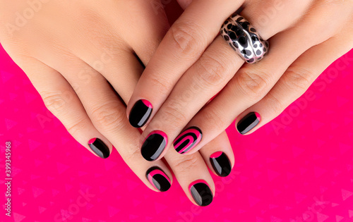 Beautiful groomed womans hands with trendy manicure on pink background