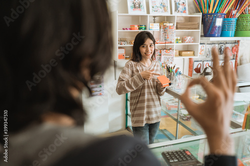 Customers visiting a stationery shop select items that show an OK sign