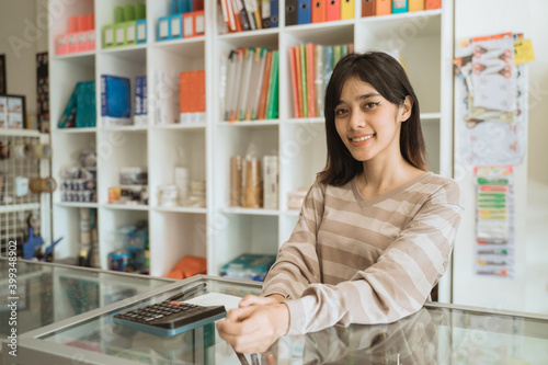 Portrait cheerful young girl entrepreneur working in a stationery shop.