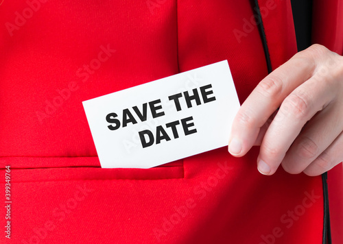 Save the date text on a card in a man's hands, close-up of a hand and a card