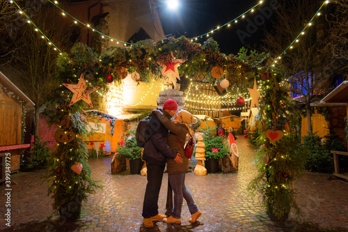 loving couple embracing on a mistletoe at an Alsace Christmas market