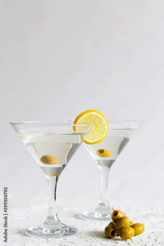 martini with lemon. Two Martini glasses with cocktail and olives on white background. Cocktail Margarita with lime on the table. copy space. alcohol drinks. vertical.