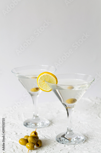 martini with lemon. Two Martini glasses with cocktail and olives on white background. Cocktail Margarita with lime on the table. copy space. alcohol drinks. vertical.