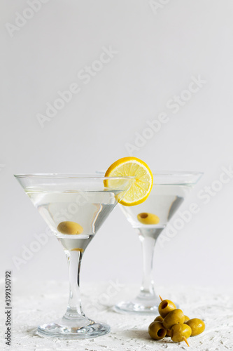 martini with lemon. Two Martini glasses with cocktail and olives on white background. Cocktail Margarita with lime on the table. copy space. alcohol drinks. vertical.