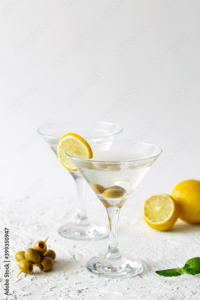 Two Martini glasses with cocktail and olives on white background. Cocktail Margarita with lime and green mint on the table. copy space. alcohol drinks. vertical.