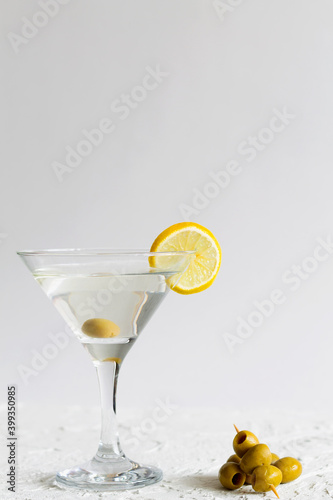 martini with lemon. Martini glass with cocktail and olives on white background. Cocktail Margarita with lime and lemon on the table. copy space. alcohol drinks. vertical