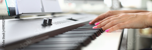 Close up of female pianist playing melody on acoustic stringed musical instrument and using music notes