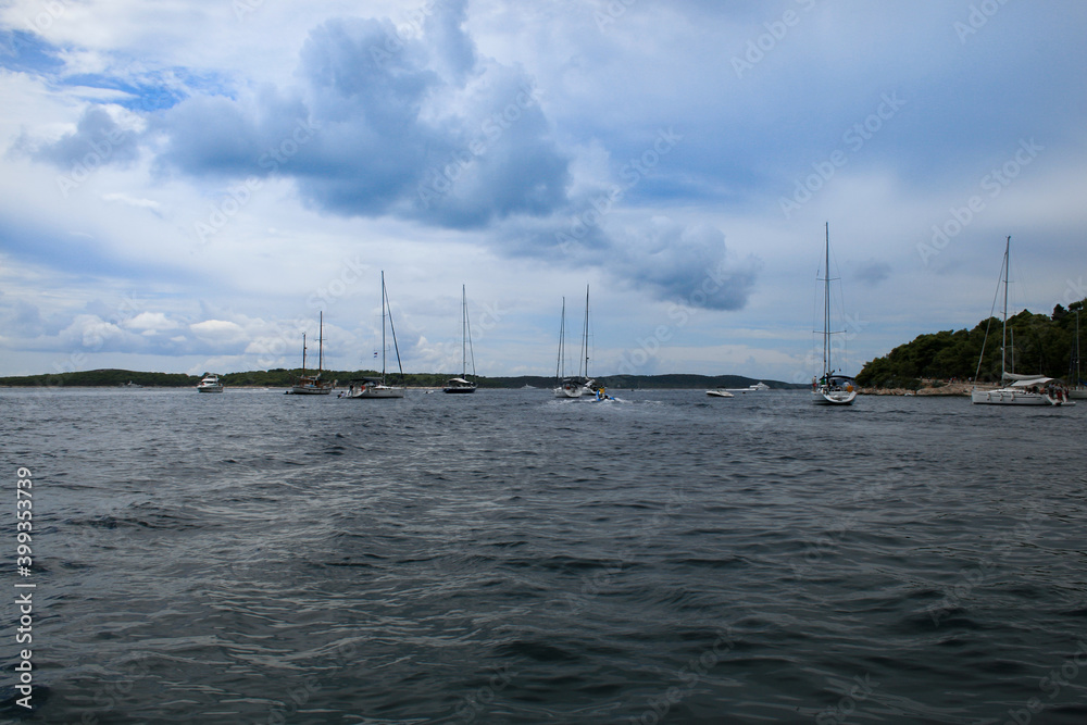 Sailboat and motorboat at sea. The blue sky is in the background.