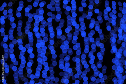 blue blurry Christmas lights on the streets. holiday night background with bokeh effect. © Pellinni