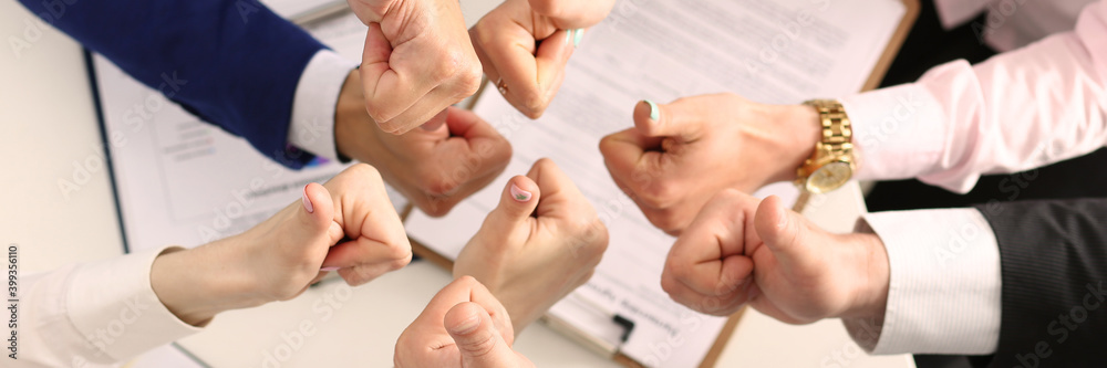 Close up of male and female hands showing approval gesture over table with documents