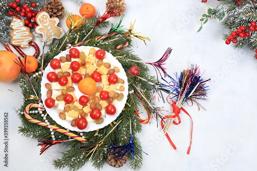 Christmas new year dishes, traditional festive salad with cheese, tomatoes, grapes and honey with fir branches and cones and decorations, dish design idea, selective focus, photo