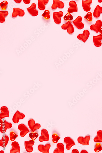 Valentine's Day, wedding, love concept. Celebration pink background with red satin hearts. Top view, flat lay, copy space.