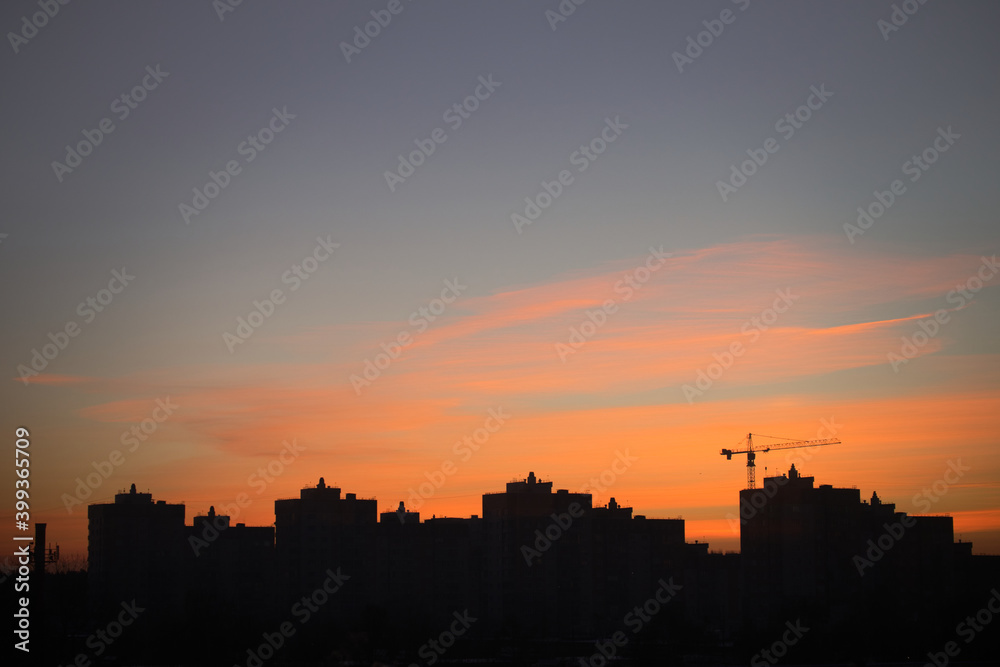 Beautiful morning sunrise in the city. The silhouettes of city buildings and beauty morning sky and clouds lighten by the rising sun. Cityscape.