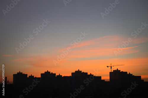 Beautiful morning sunrise in the city. The silhouettes of city buildings and beauty morning sky and clouds lighten by the rising sun. Cityscape.
