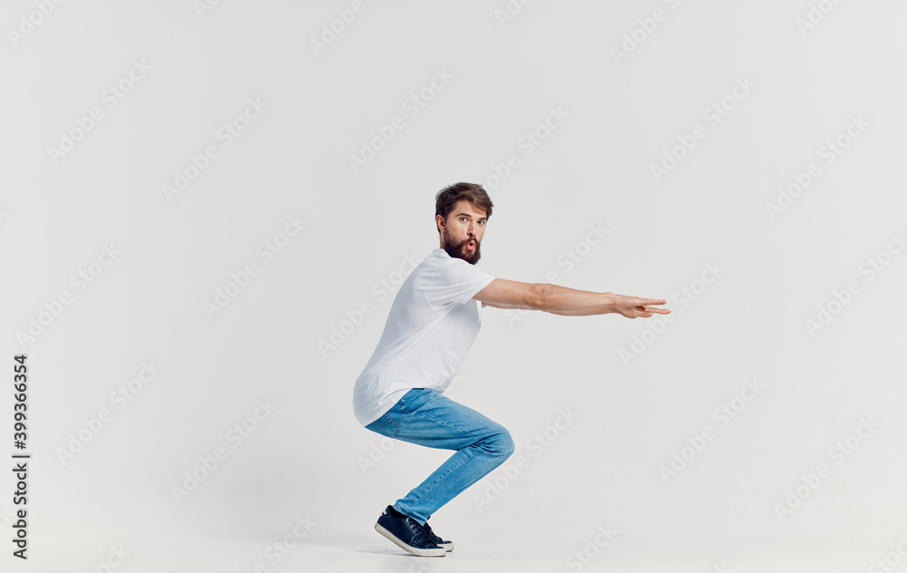 cheerful man in white t-shirt and jeans casual clothes studio isolated background