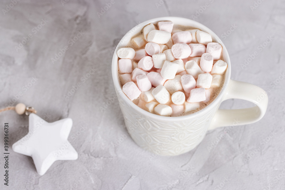 Cup of cocoa or chocolate with marshmallows and star Christmas decoration, light gray background. Winter hot beverage concept Flat lay, top view, copy space