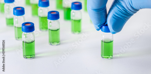Scientist puts vial with plant extracts for HPLC analysis. Natural products for development drugs and pharmaceuticals.