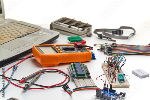 The concept of a microprocessor device assembled on a breadboard.Programmer, Arduino and peripheral blocks for ssembly. photo