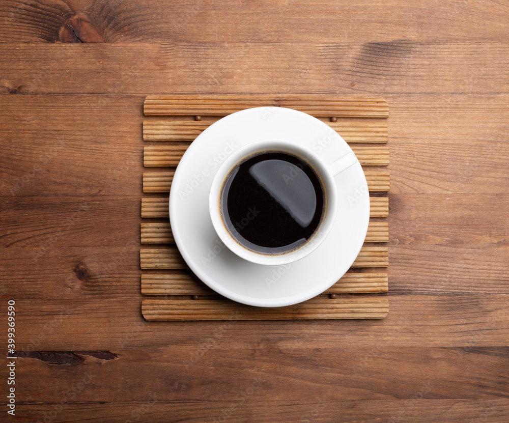 A cup of hot coffee on old wooden table in a cafe. White cup of coffee in the morning. A cup of hot coffee on old wooden table in a cafe. White cup of coffee in the morning.