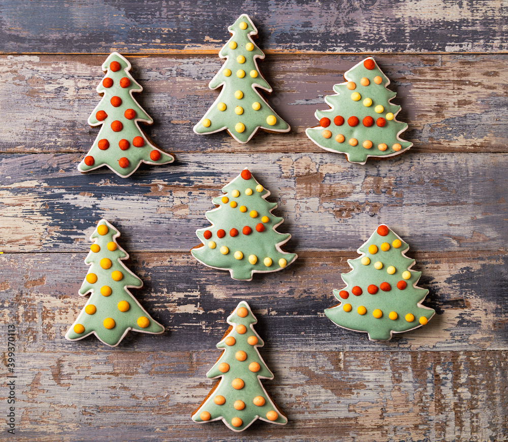 Festive Christmas and New Year gingerbread in the shape of fir tree on blue wooden background Festive Christmas and New Year gingerbread in the shape of fir tree on blue wooden background