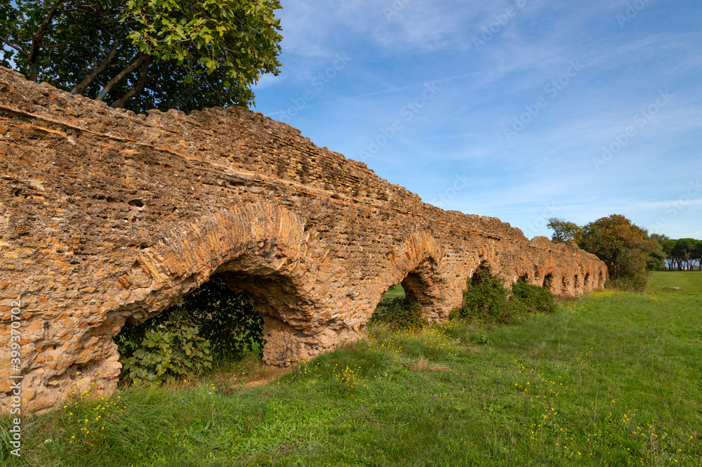 Perspective of the Alexandrian Aqueduct, the last of the Roman aqueducts, built by Emperor Alexander Severus. Detail of the arches and bricks on a sunny day and blue sky centocelle area. Rome.