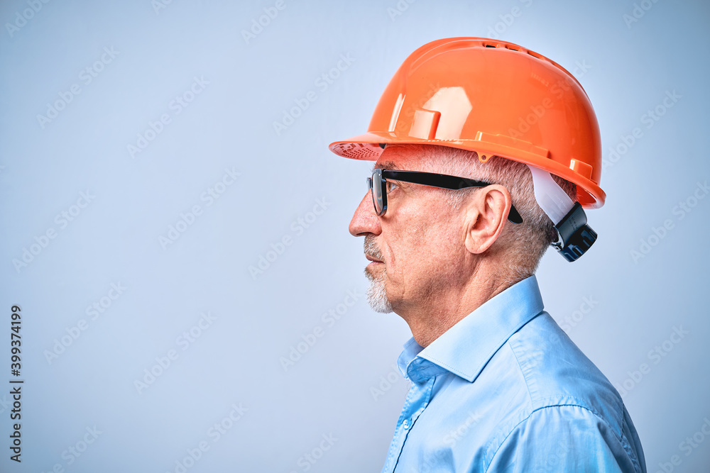 Mature engineer in black glasses and a protective helmet Mature engineer in black glasses and a protective helmet