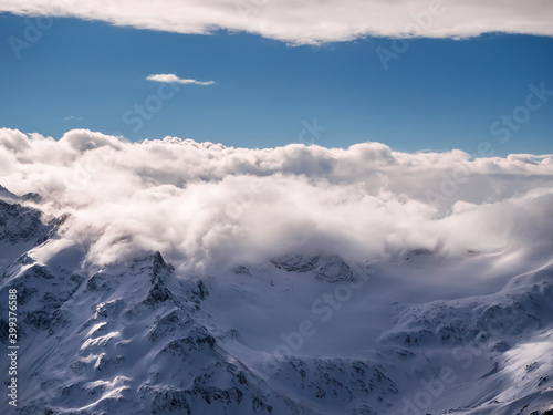 Top view of winter mountains covered with clouds