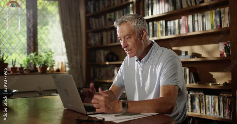 4K handsome senior man looking stressed out while working on his laptop at home 4K handsome senior man looking stressed out while working on his laptop at home