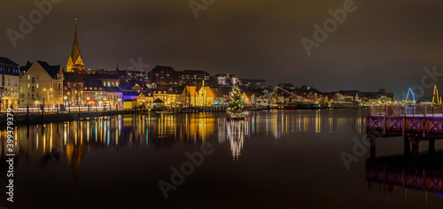 Panorama view of  of festive lighting and Christmas romantic atmosphere in the Flensburg at night. Nighttime view of Flensburg Förde at Christmas time. Maritime Christmas city. photo