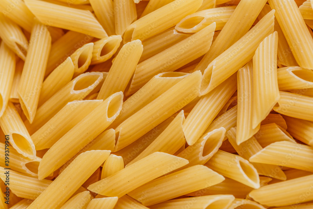 Dry pasta Pennoni Rigati.Pennoni Rigati have shape and yellow color. Pasta is delicious Italian traditional food made from wheat flour like noodles.Dry pasta background.Top view Dry pasta Pennoni Rigati.Pennoni Rigati have shape and yellow color. Pasta is delicious Italian traditional food made from wheat flour like noodles.Dry pasta background.Top view