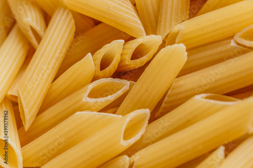 Dry pasta Pennoni Rigati.Pennoni Rigati have shape and yellow color. Pasta is delicious Italian traditional food made from wheat flour like noodles.Dry pasta background.Top view