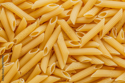 Dry pasta Pennoni Rigati.Pennoni Rigati have shape and yellow color. Pasta is delicious Italian traditional food made from wheat flour like noodles.Dry pasta background.Top view