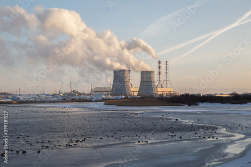 View of a power plant on the shores of the Gulf of Finland at dawn in winter. Southwest Thermal Power Plant Saint Petersburg Russia. Smoke from chimneys. © Алексей Васильев