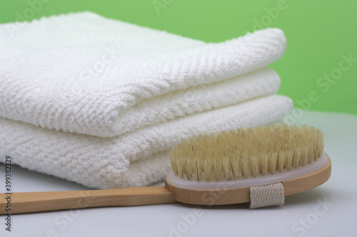Closeup of some white towels next to a shower brush