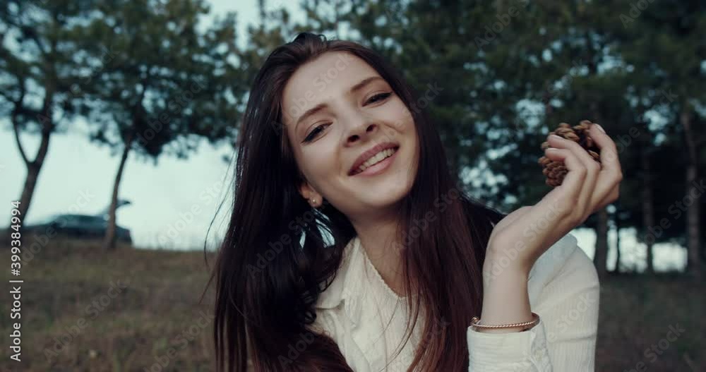 portrait of a young and beautiful girl in the park, sitting down. Slow motion 4k