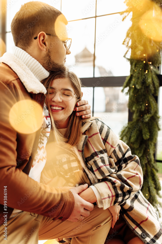 Lovely young couple cuddling at home, adorable woman smiling, enjoy tender moments, festive Christmas mood, New Year celebration, cozy winter holidays concept