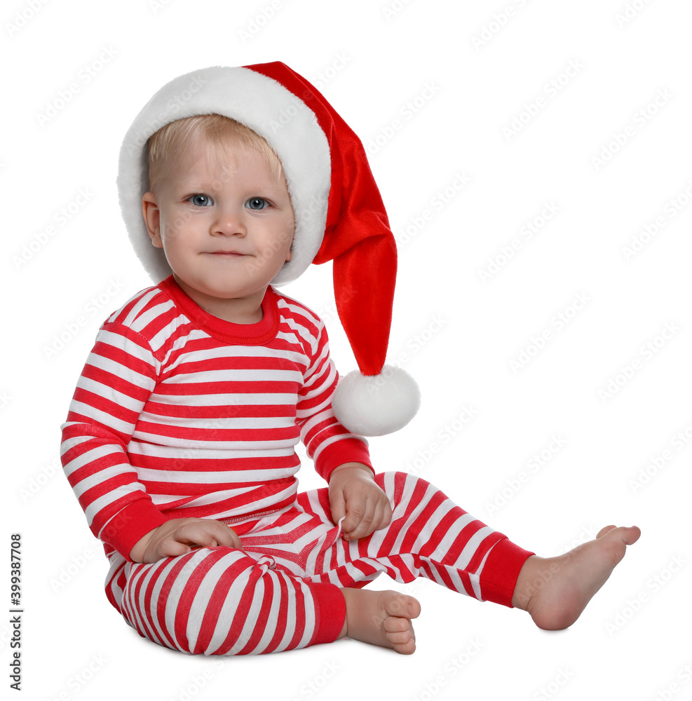 Cute baby in Santa hat and Christmas pajamas sitting on white background Cute baby in Santa hat and Christmas pajamas sitting on white background