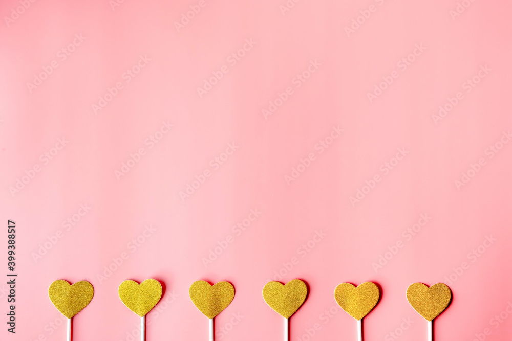 Obraz premium gold hearts on pink paper background. happy valentine's day, minimalism concept