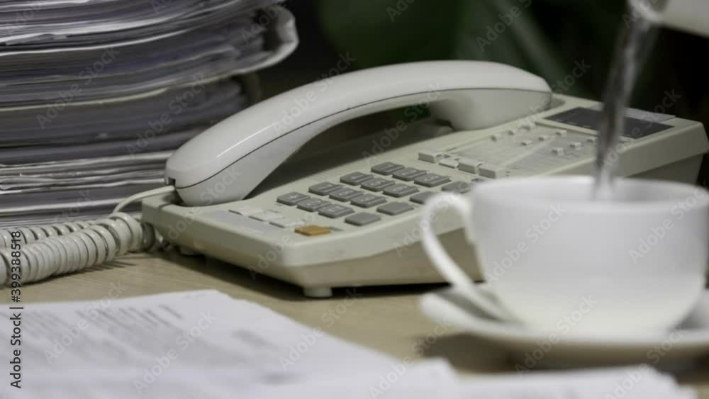 Office worker uses a phone to answer incoming calls and dialing a number to make a call. Businesswoman picking up the telephone. Close-up of women's hands, workplace Office worker uses a phone to answer incoming calls and dialing a number to make a call. Businesswoman picking up the telephone. Close-up of women's hands, workplace