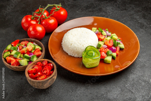 Close up view of homemade rice dish and vegetables on dark background